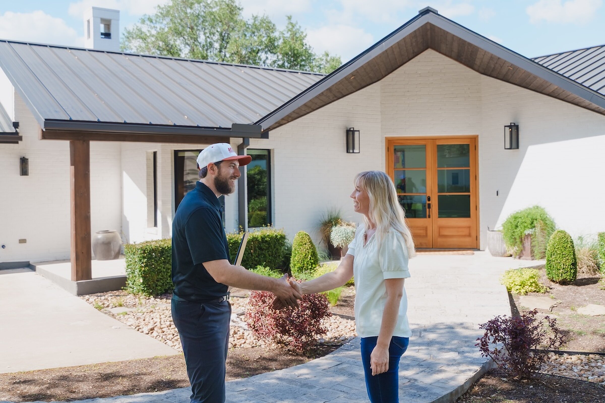 Action Exteriors rep greeting a homeowner with a handshake at the front door