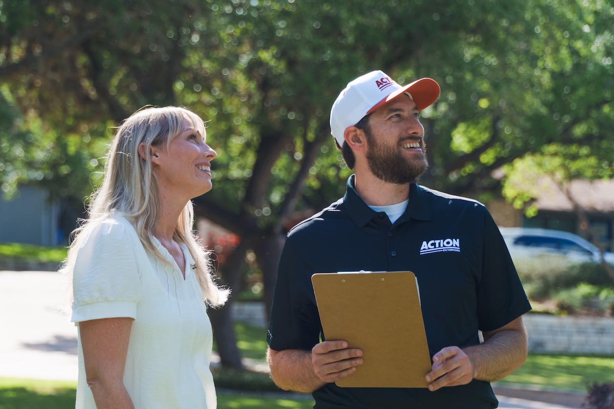 Action Exteriors rep consulting with a homeowner outside her home