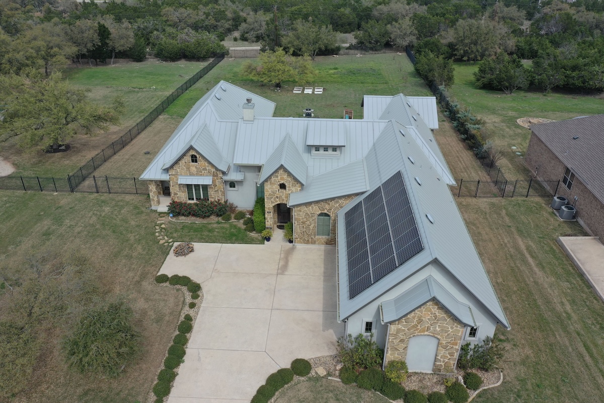Aerial view of professionally installed roof shingles with warranty coverage - Action Exteriors
