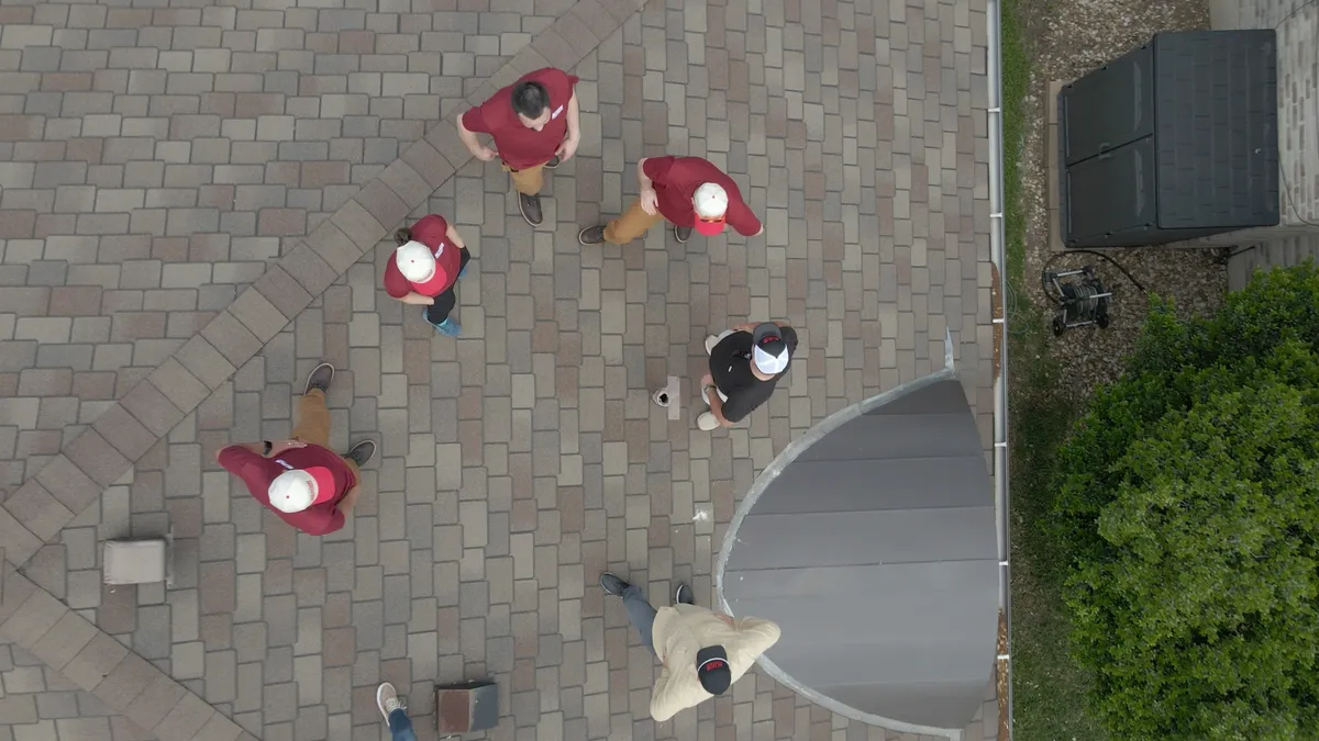 Aerial view of Action Exteriors team in red shirts on brick pavers