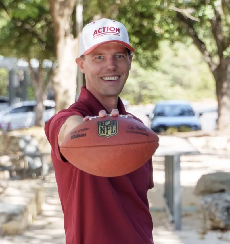 Jordan from Action Exteriors holding a football for insurance claims support - Action Exteriors