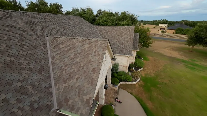 Aerial view of professionally installed roof shingles with warranty coverage - Action Exteriors