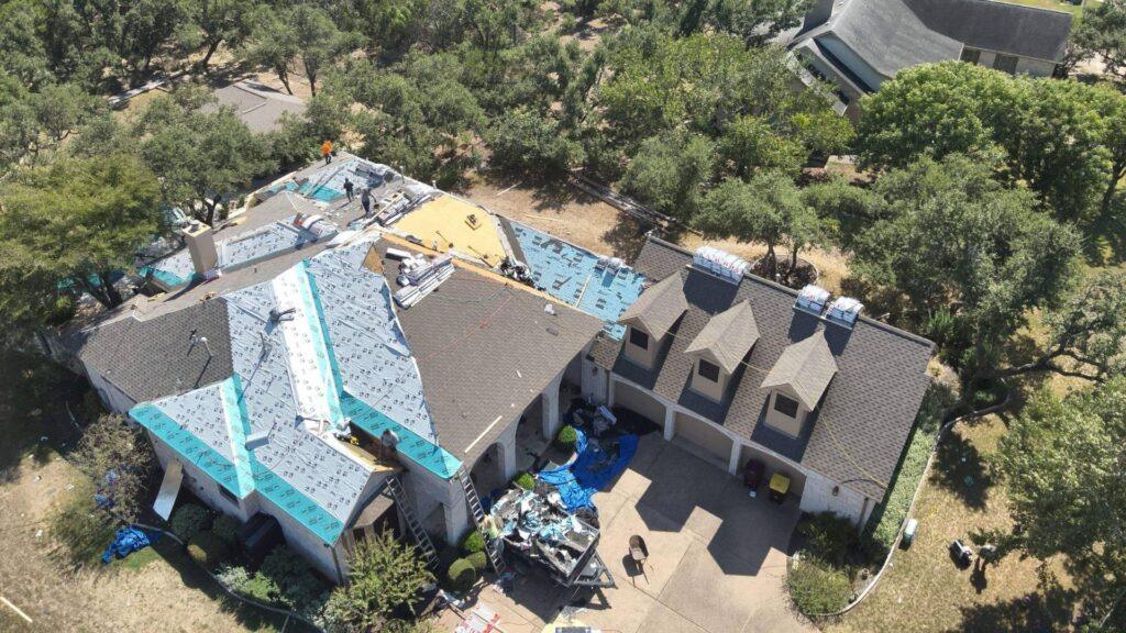 A roof that is being replaced by Action Exteriors Austin in a residential neighborhood.