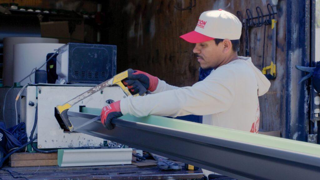 Action Exteriors employee working to cut metal for a residential roof replacement in Austin - emergency roof repair