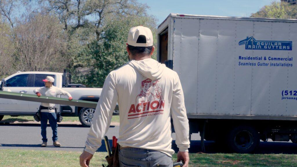 Action Exteriors Austin employee walking back to the truck to get supplies for a commercial roof replacement.