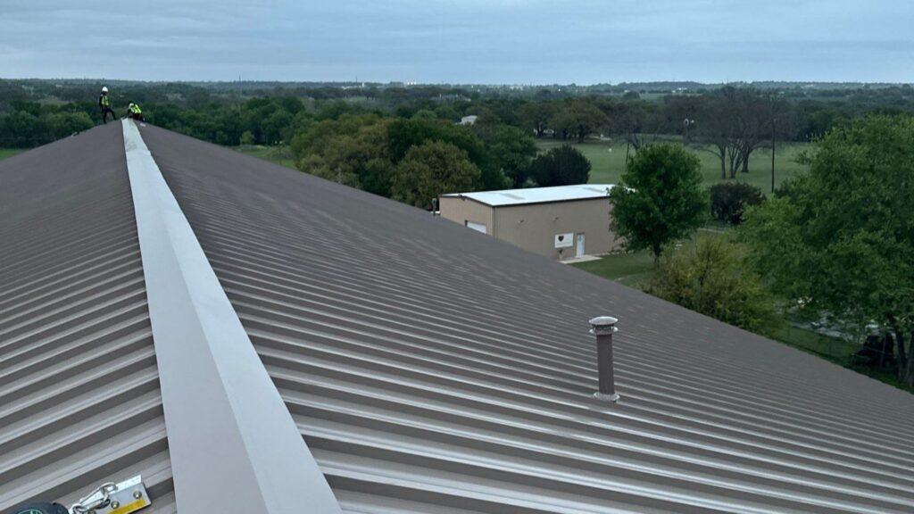 Commercial Metal roofing services taking place on a business by Action Exteriors Austin.