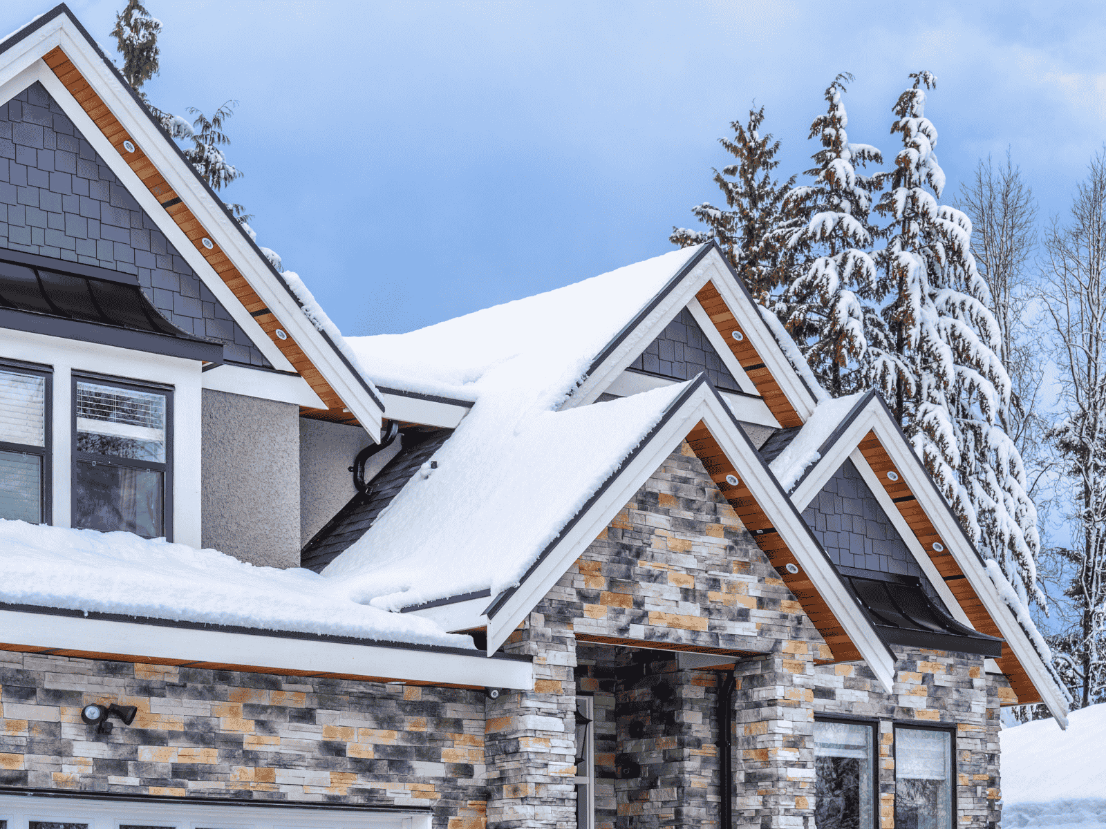 How to prepare your roof for the winter. Residential house with snow and ice on the roof_Action exteriors