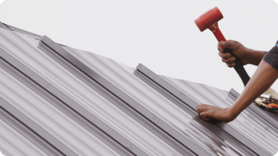 Commercial Roofing Maintenance taking place on a metal roof by Action Exteriors