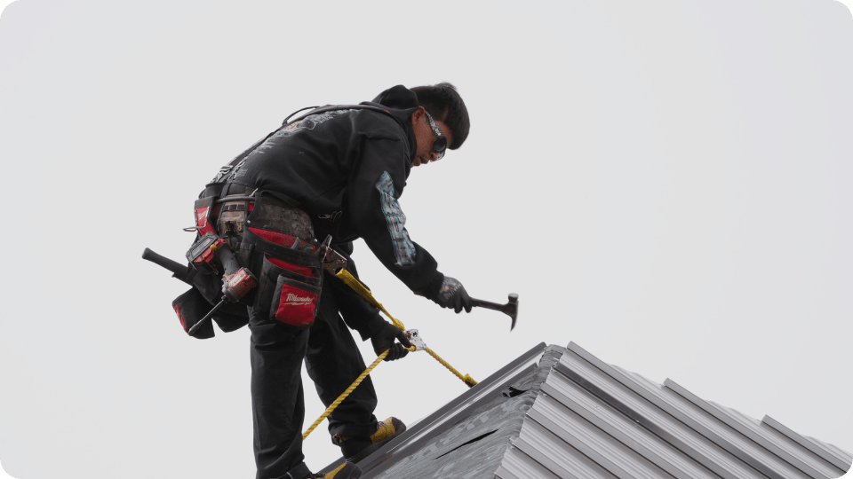 roofer hammering up on the roof for action exteriors roofing services