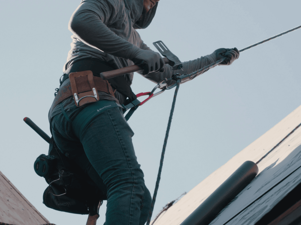 Action Exterior roofer inspecting a roof for a roof repair