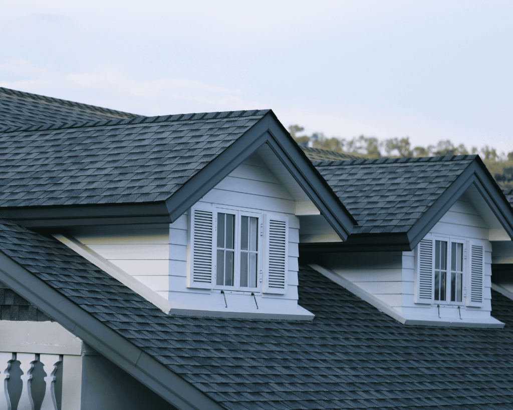 a close up of a two story home with white siding and a dark gray asphalt roof_action exteriors professional residential roof repair experts