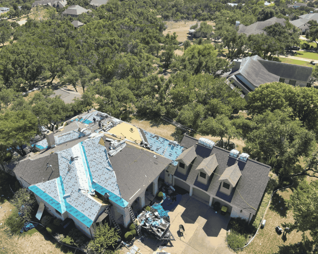 aerial view of a large home undergoing an entire roof replacement