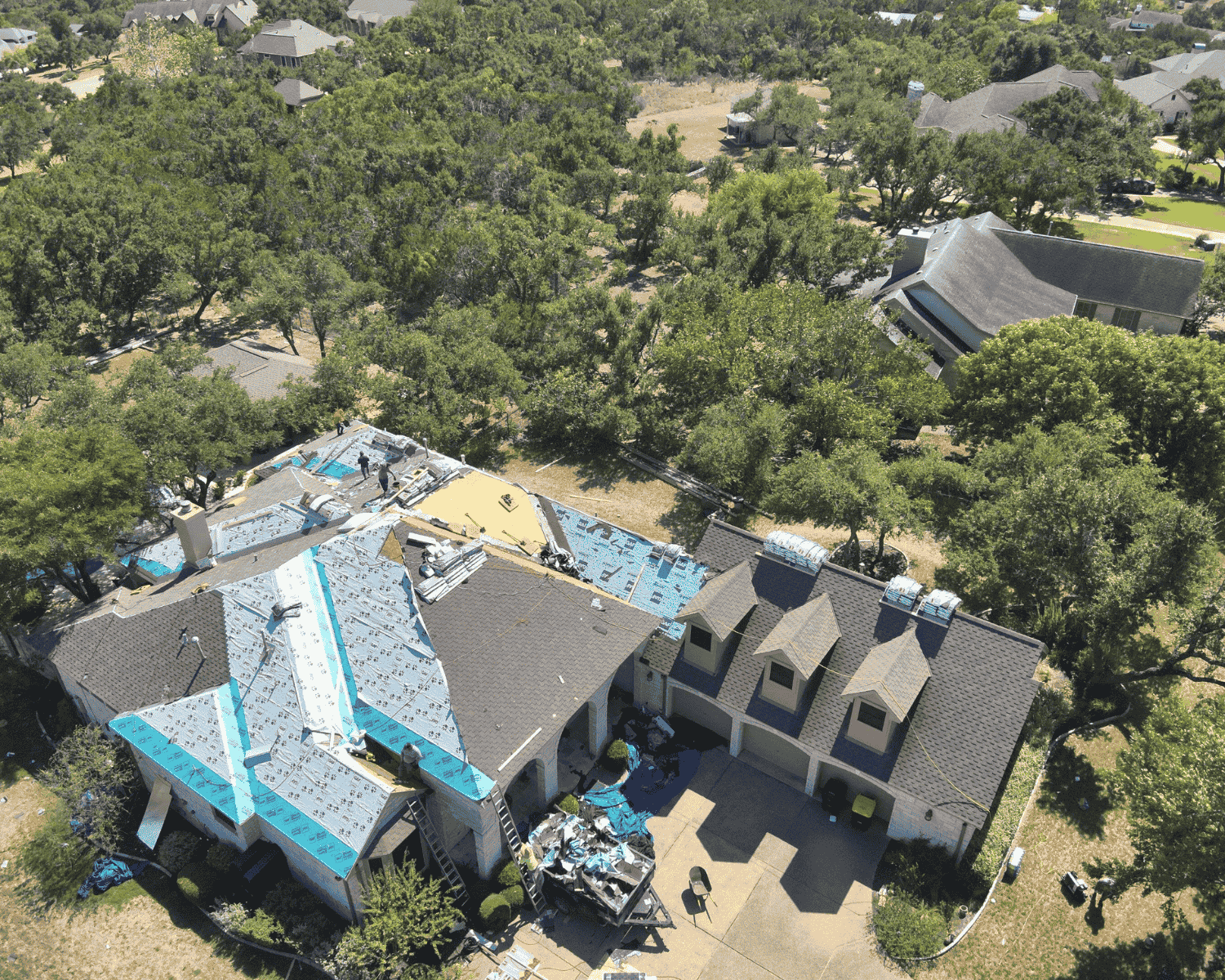 aerial view of a large home undergoing an entire roof replacement