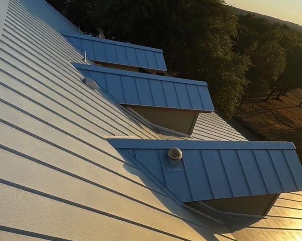 Metal roofing contractors put in a new roof on a home.