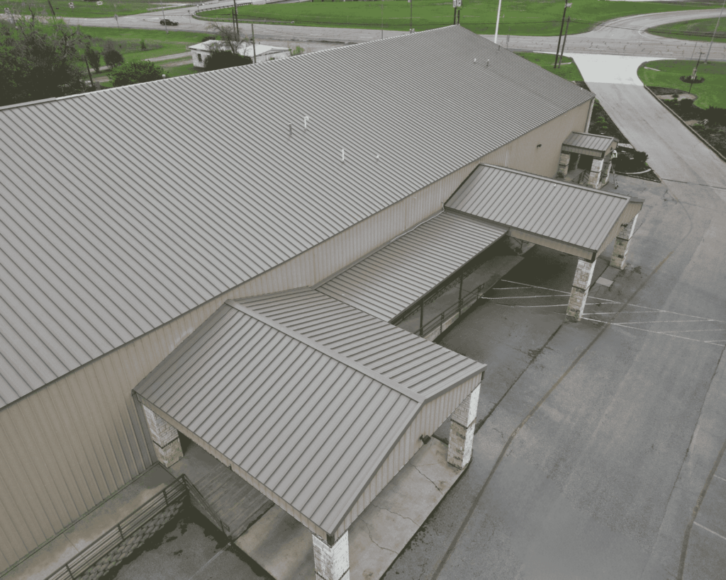 a silver commercial roof recently repaired by professional roofers at action exteriors