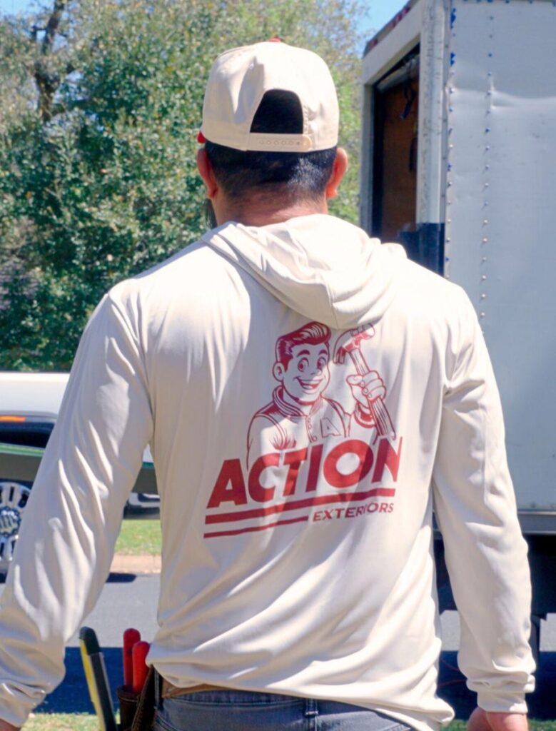 two employees of action exteriors, a commercial roofing company, installing materials for a commercial roofing project - hail-damaged roof