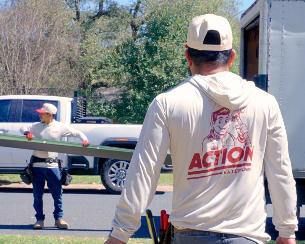 two employees of action exteriors, a commercial roofing company, installing materials for a project