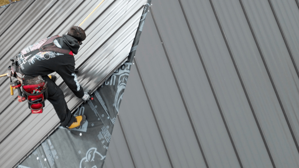 a professional roofer working on a commercial roof repair project using a metal roof_action exteriors
