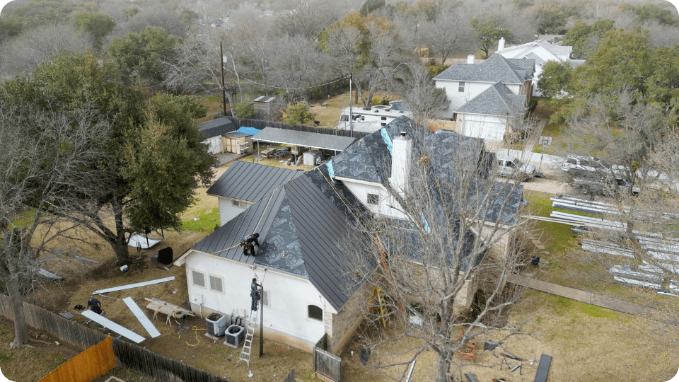 a large two story white home undergoing a total roof renovation_action exteriors