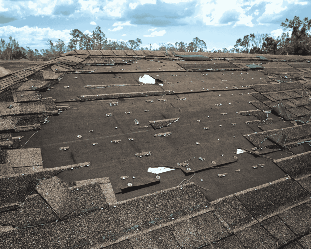 a roof heavily damaged by a storm with missing shingles_action exteriors